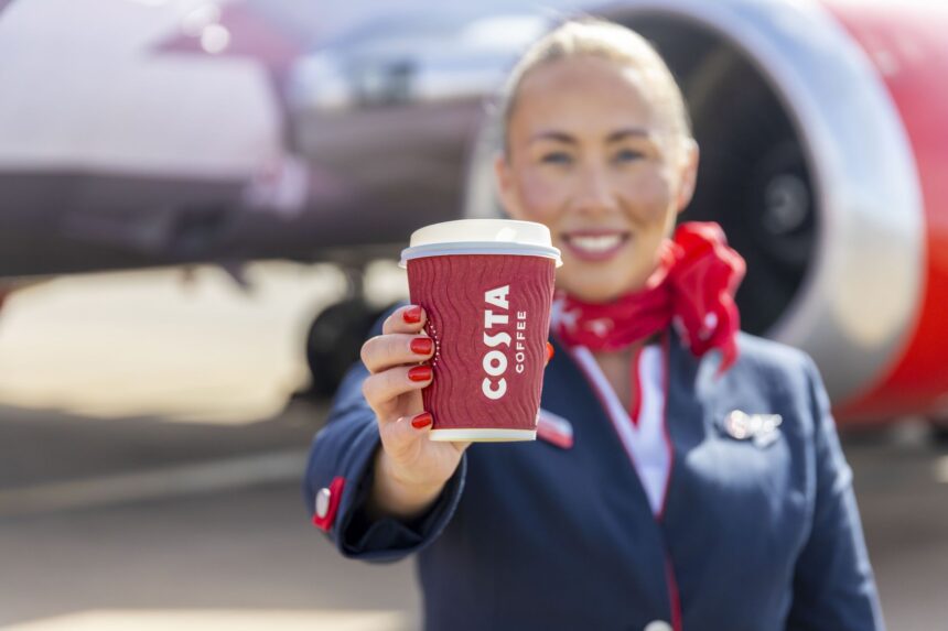 A member of Jet2 crew proudly displays a cup of Costa Coffee.