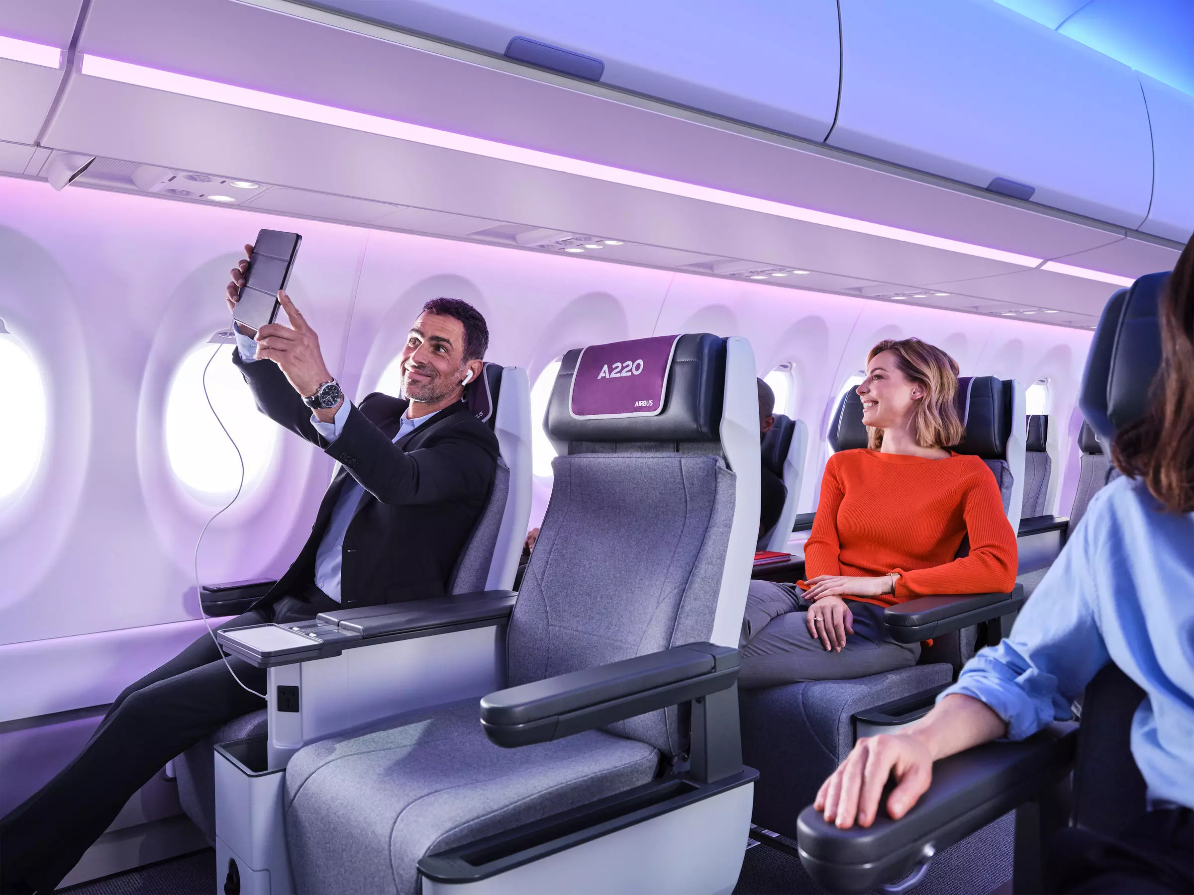 An image of a man taking a selfie onboard the Airbus A220 aircraft, showcasing its roomy seating.