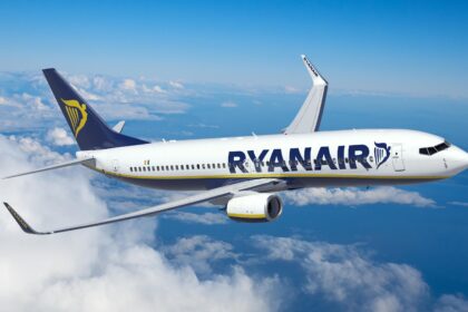 An image of a Ryanair aircraft mid-flight in the clouds.