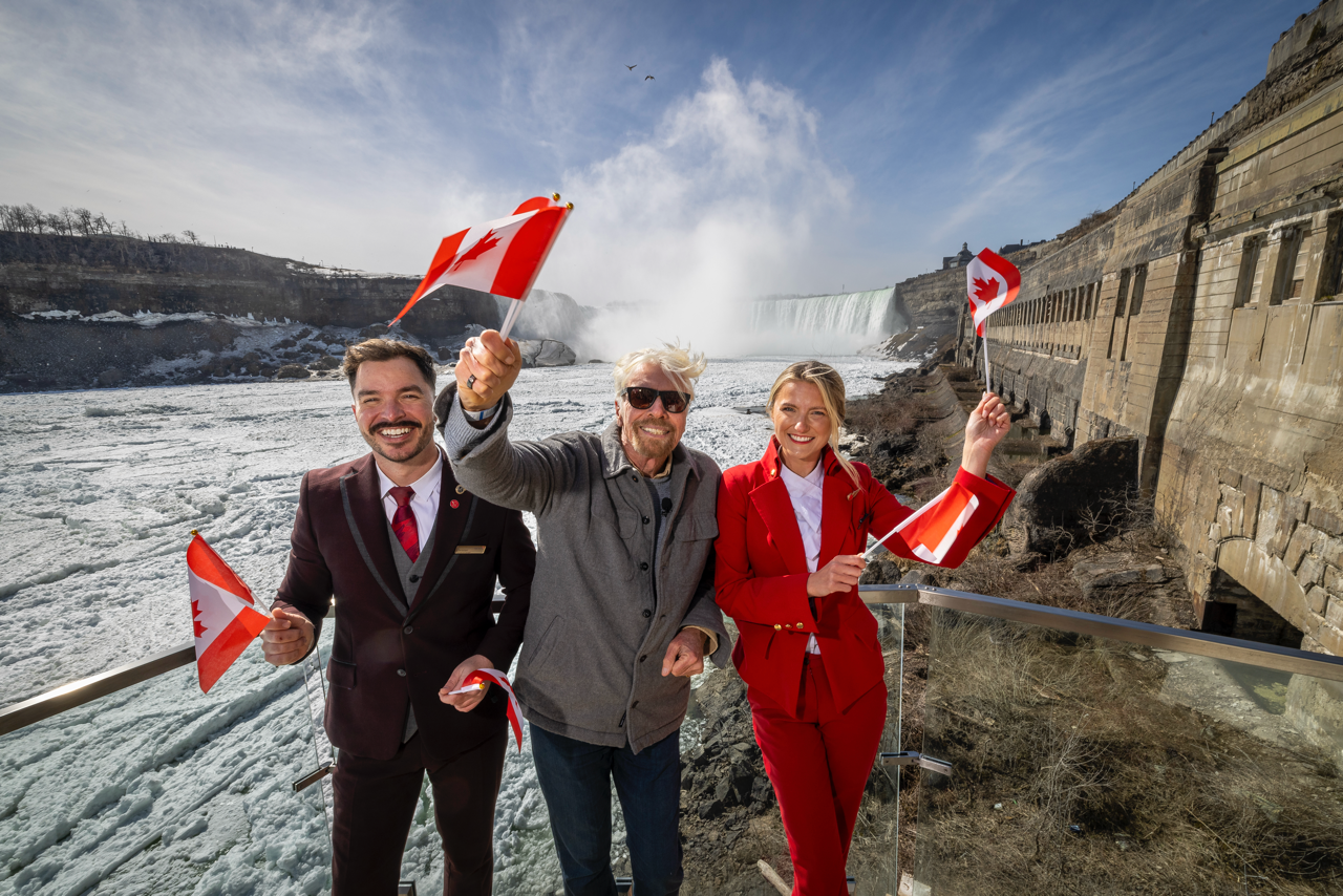 Sir Richard Branson and the team celebrate in Canada and wave Canadian flags.