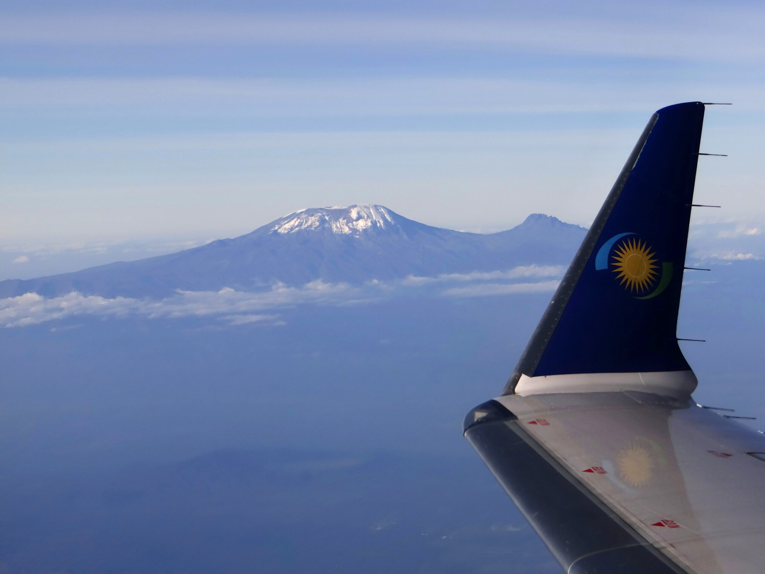 An image of a RwandAir jet wing over Mount Kilimanjaro, Tanzania.