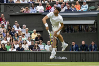 Emirates sponsorship behind Carlos Alcaraz (ESP) who serves against Frances Tiafoe (USA) in the third round of the Gentlemen's Singles on Centre Court at The Championships 2024
