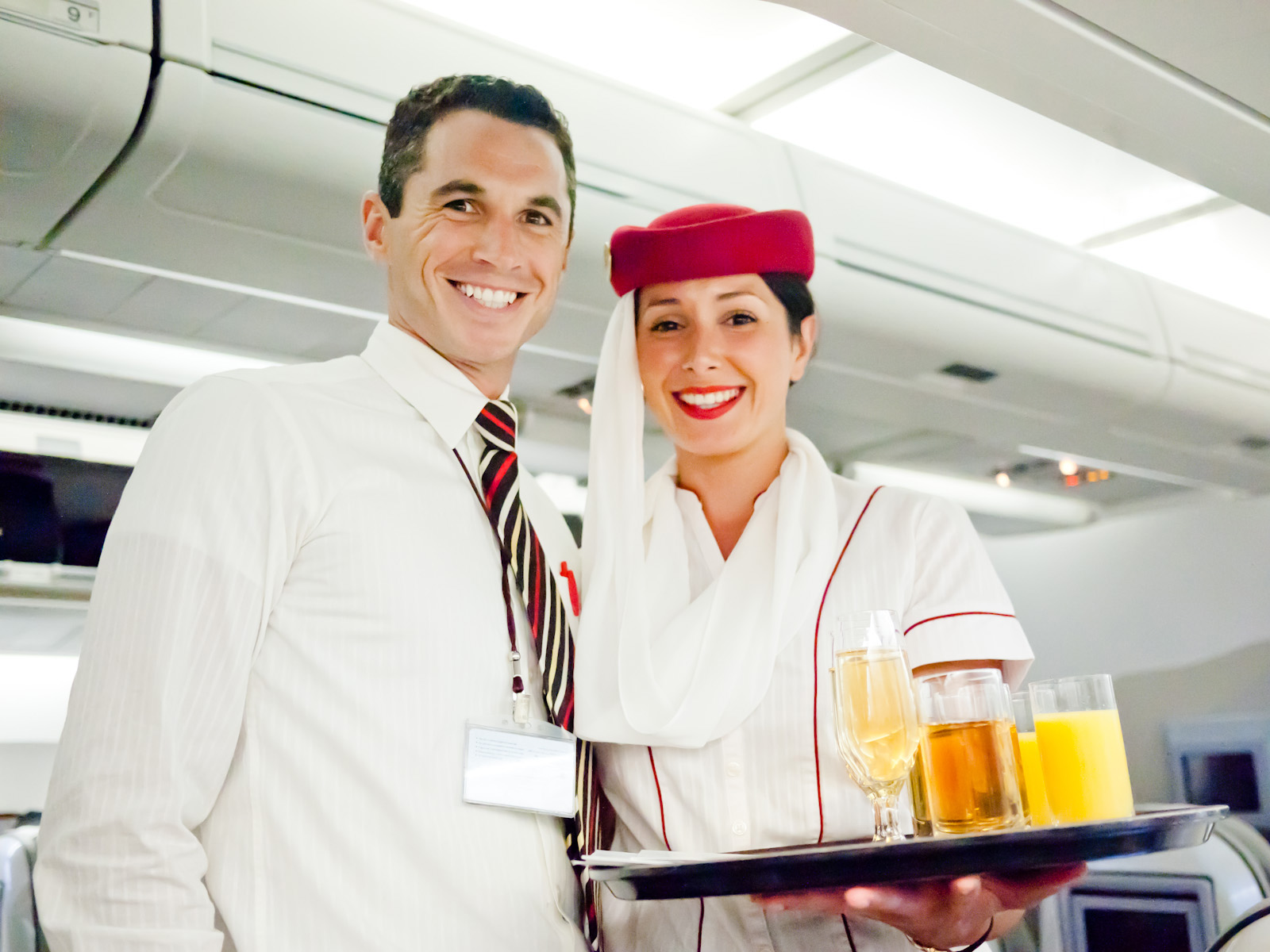 Emirates flight attendants serving refreshments.