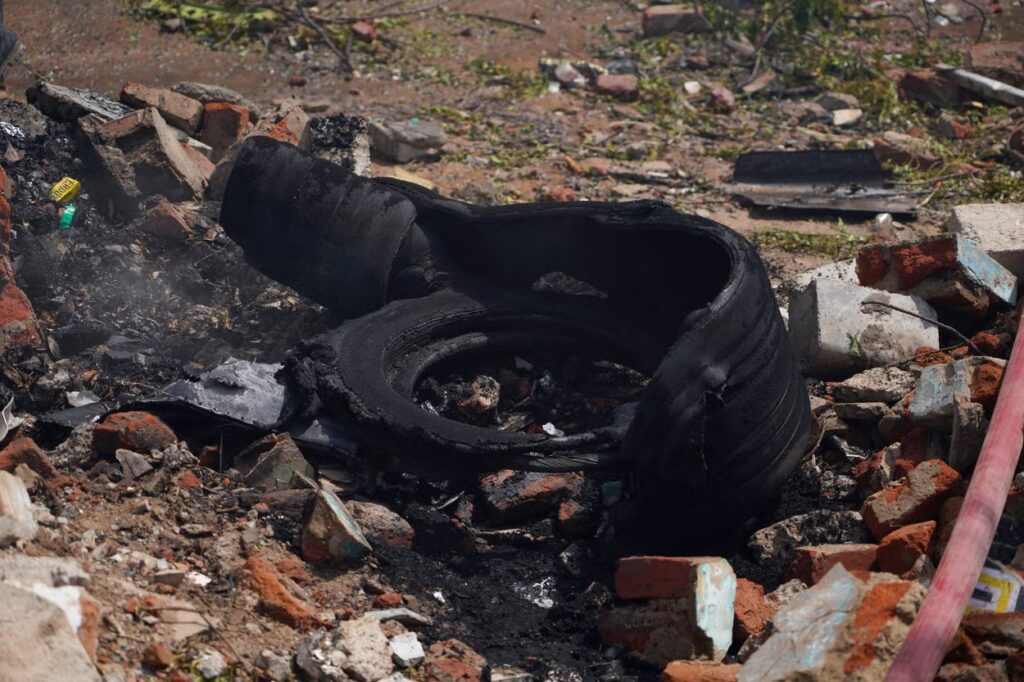 Emergency responders at the crash site of Air India flight AI171 near Ahmedabad Airport, with smoke rising from debris and rescue teams searching the wreckage.