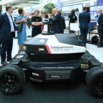 A robot stands on display at an event, highlighting advancements in robotics and technology.