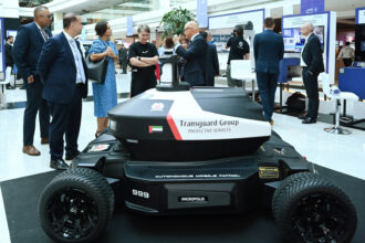 A robot stands on display at an event, highlighting advancements in robotics and technology.