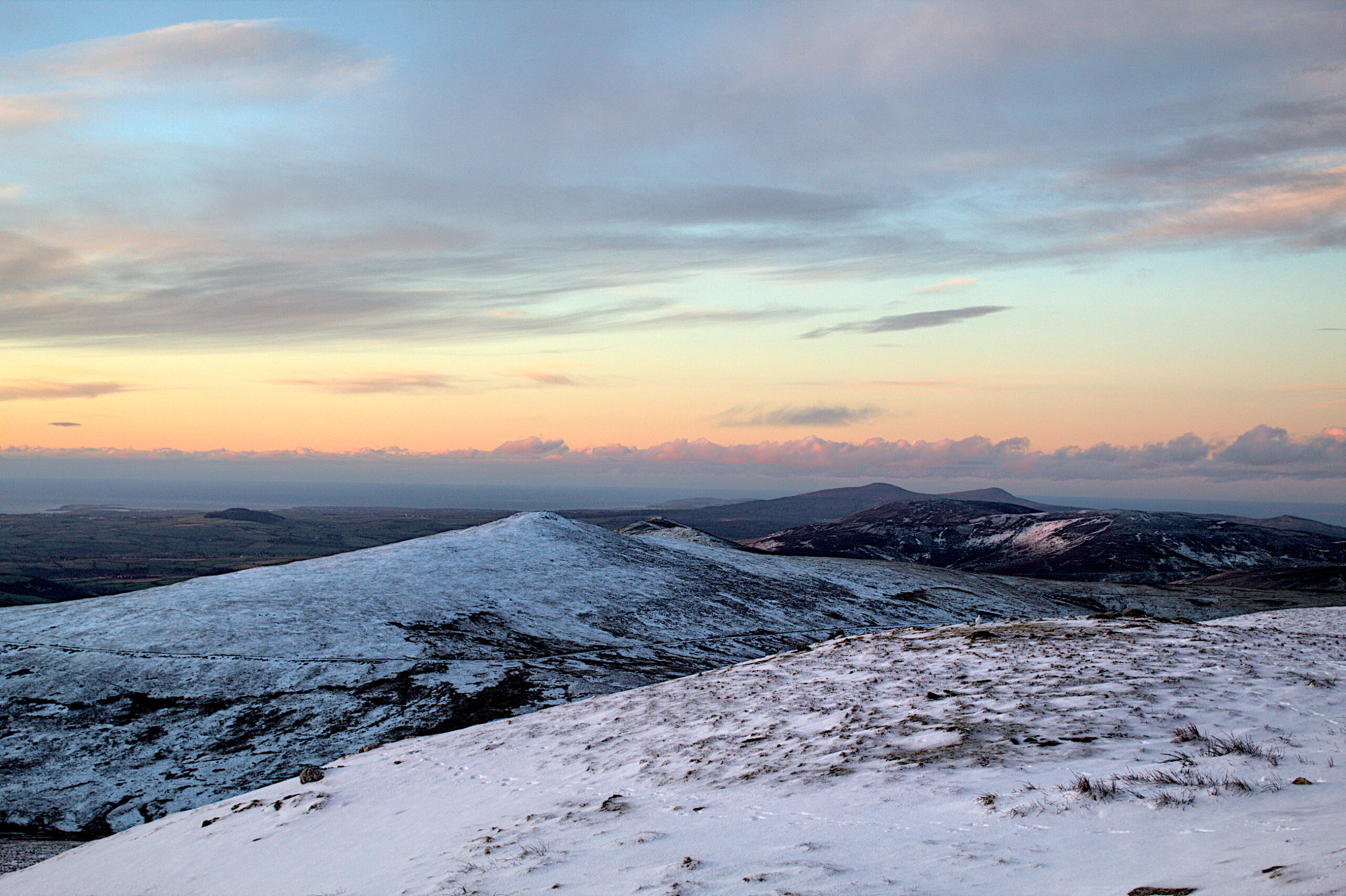 A sunrise above a snowy mountain on the Isle of Man