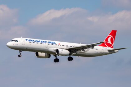 A Turkish Airline jet preparing for landing into Hamburg Airport during daytime.