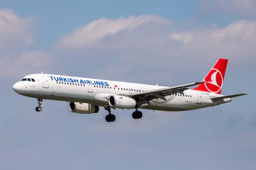 A Turkish Airline jet preparing for landing into Hamburg Airport during daytime.