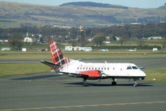 An image of a Loganair aircraft at Glasgow Airport with its iconic tartan tail.