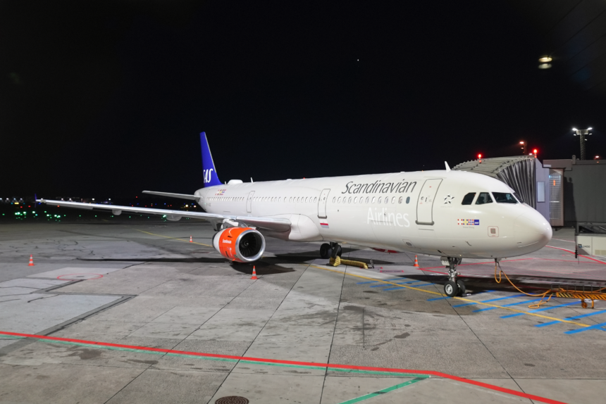 An image of a Scandinavian airlines A321-200 at night at Copenhagen Airport.