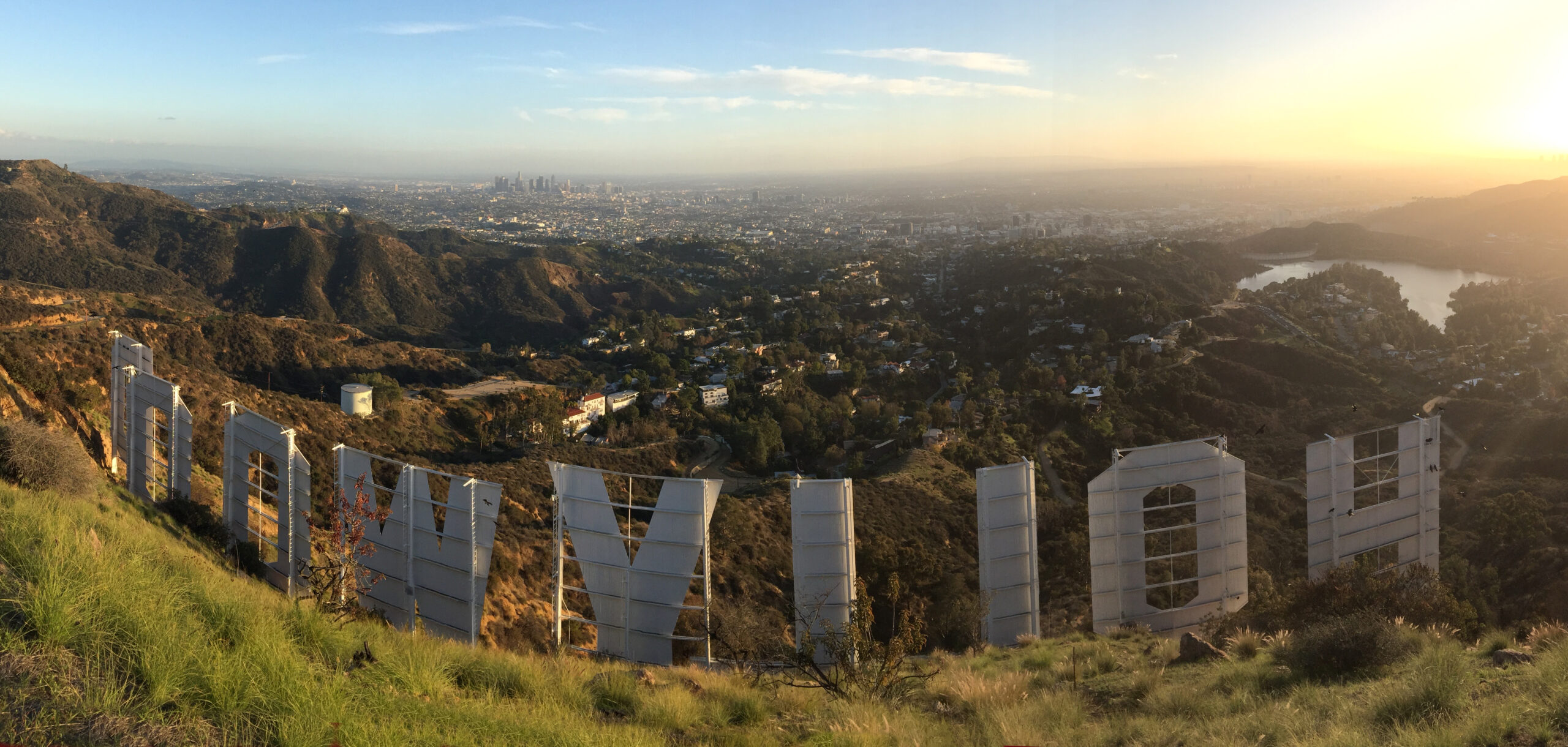 An image behind the famous Hollywood sign with a view of Los Angeles in the background.