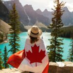 Woman Draped In A Flag Of Canada with mountains in the background