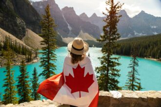 Woman Draped In A Flag Of Canada with mountains in the background