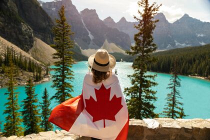 Woman Draped In A Flag Of Canada with mountains in the background
