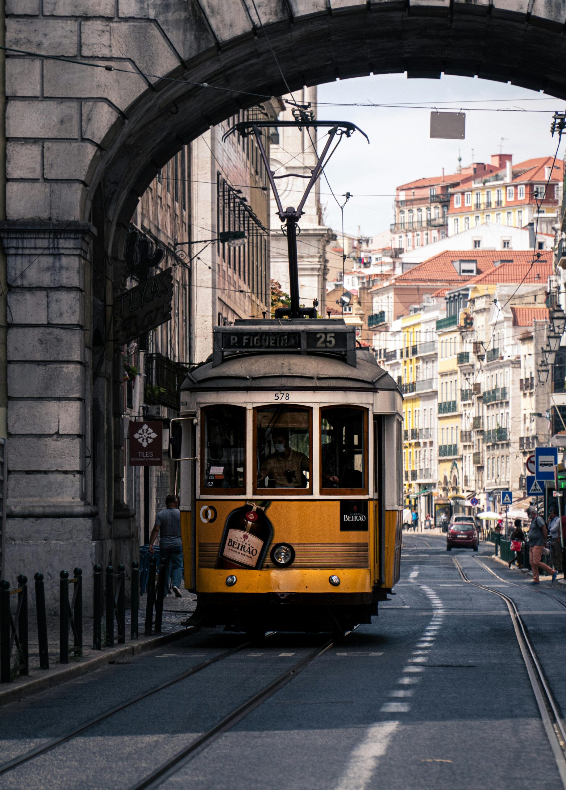 An image of a yellow tram in a Lisbon street.