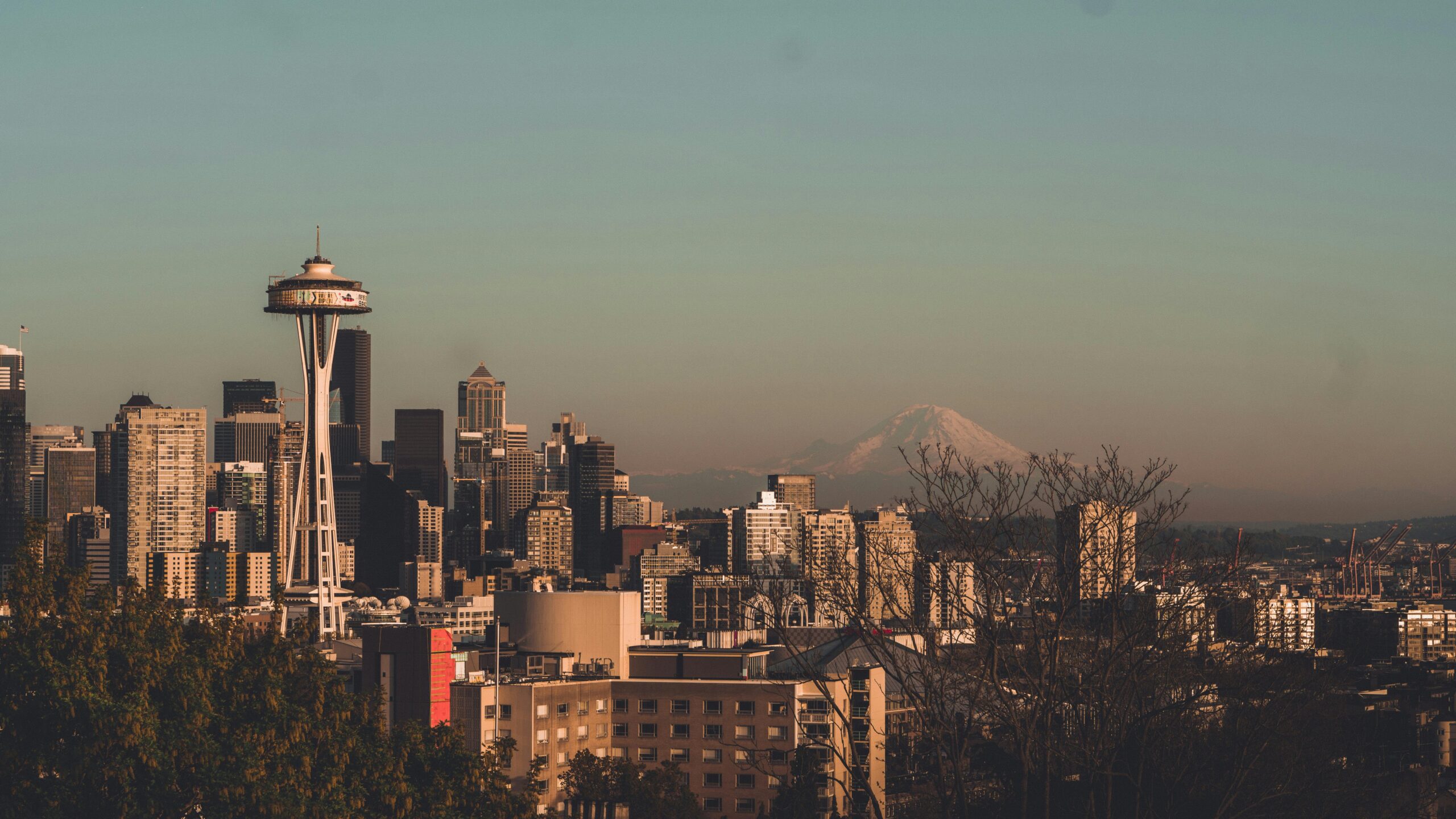 A view of Seattle's skyline with the famous Space Needle in the foreground and Mount Rainier behind it.