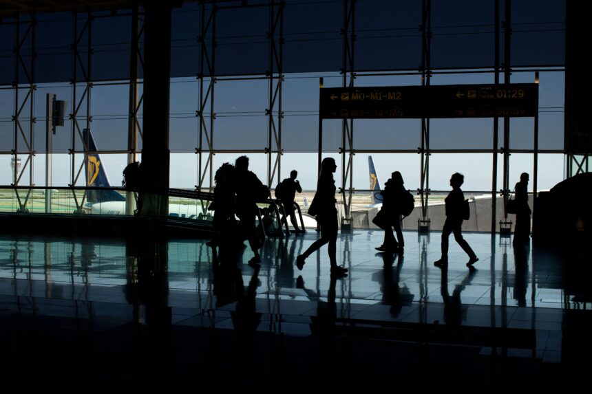 Silhouettes of people at the airport with aircrafts in the background