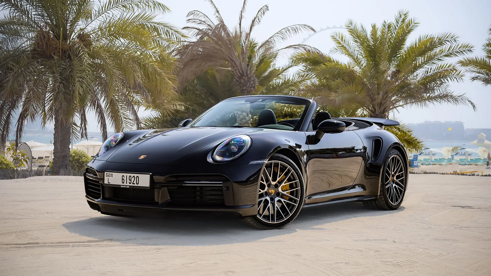 Black Porsche 911 with palms in the background