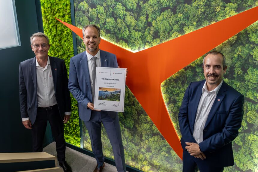 Deutsche Aircraft CEO Nico Neumann (center) holds the signed contract during the official partnership ceremony with Hutchinson, marking a significant step in sustainable aviation collaboration