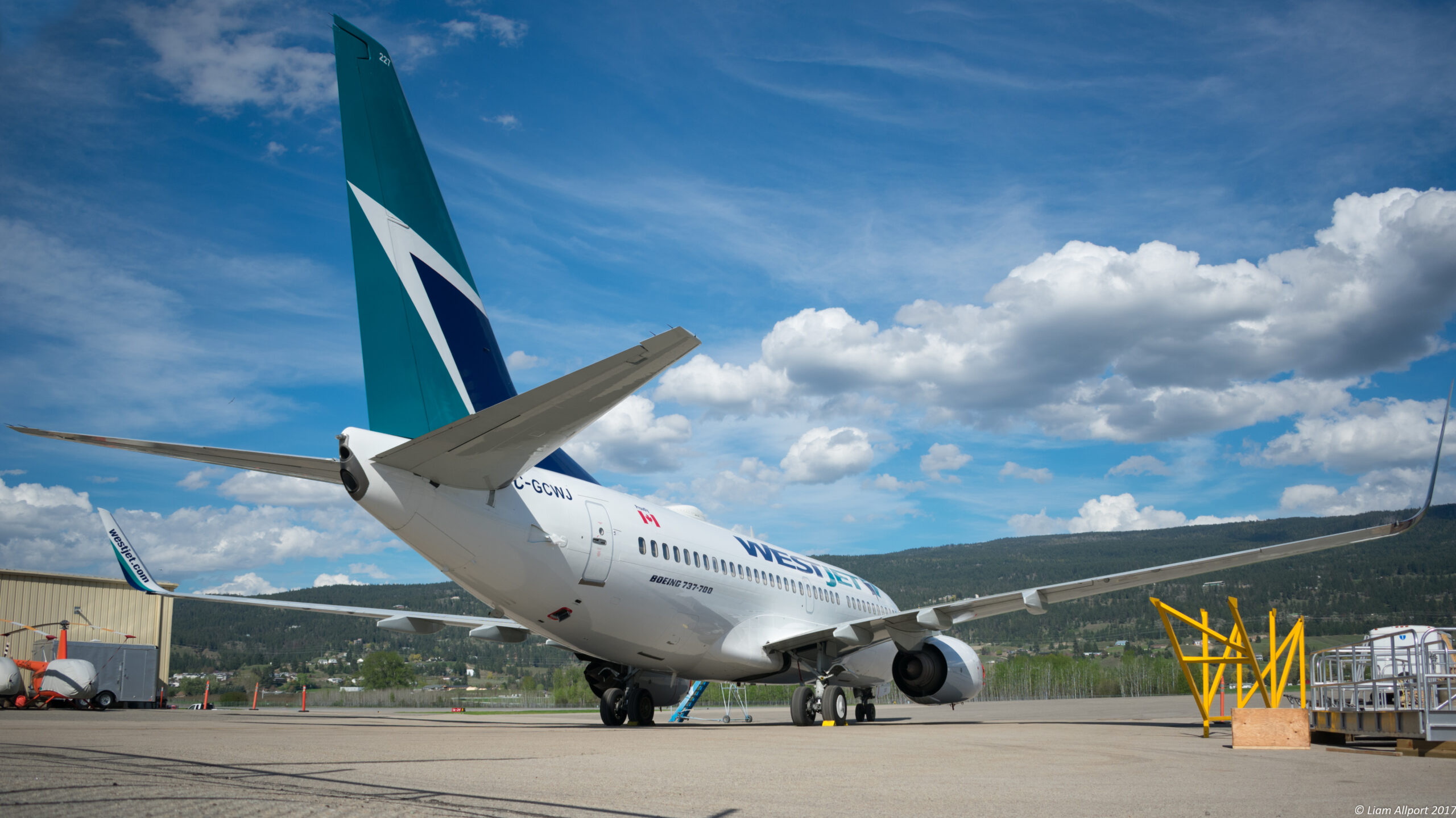 An image of a WestJet Boeing 737-7CT on the tarmac at an airport.