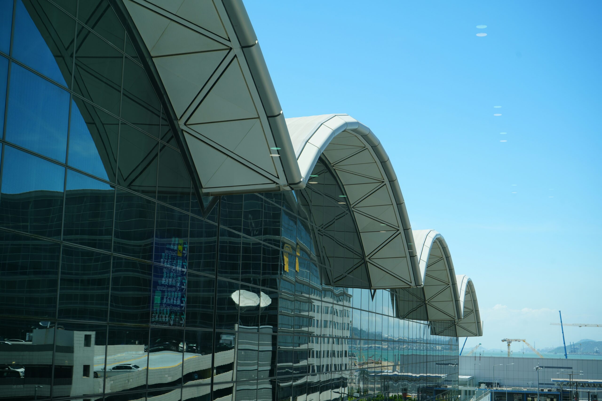 The building of the Hong Kong Airport, highlighting its vast structure and significant presence in the environment.