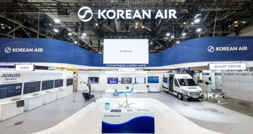 Exhibition booth for Korean Air showcasing Smart Drone technology. Features a drone on a platform, screens with data, and a model aeroplane.