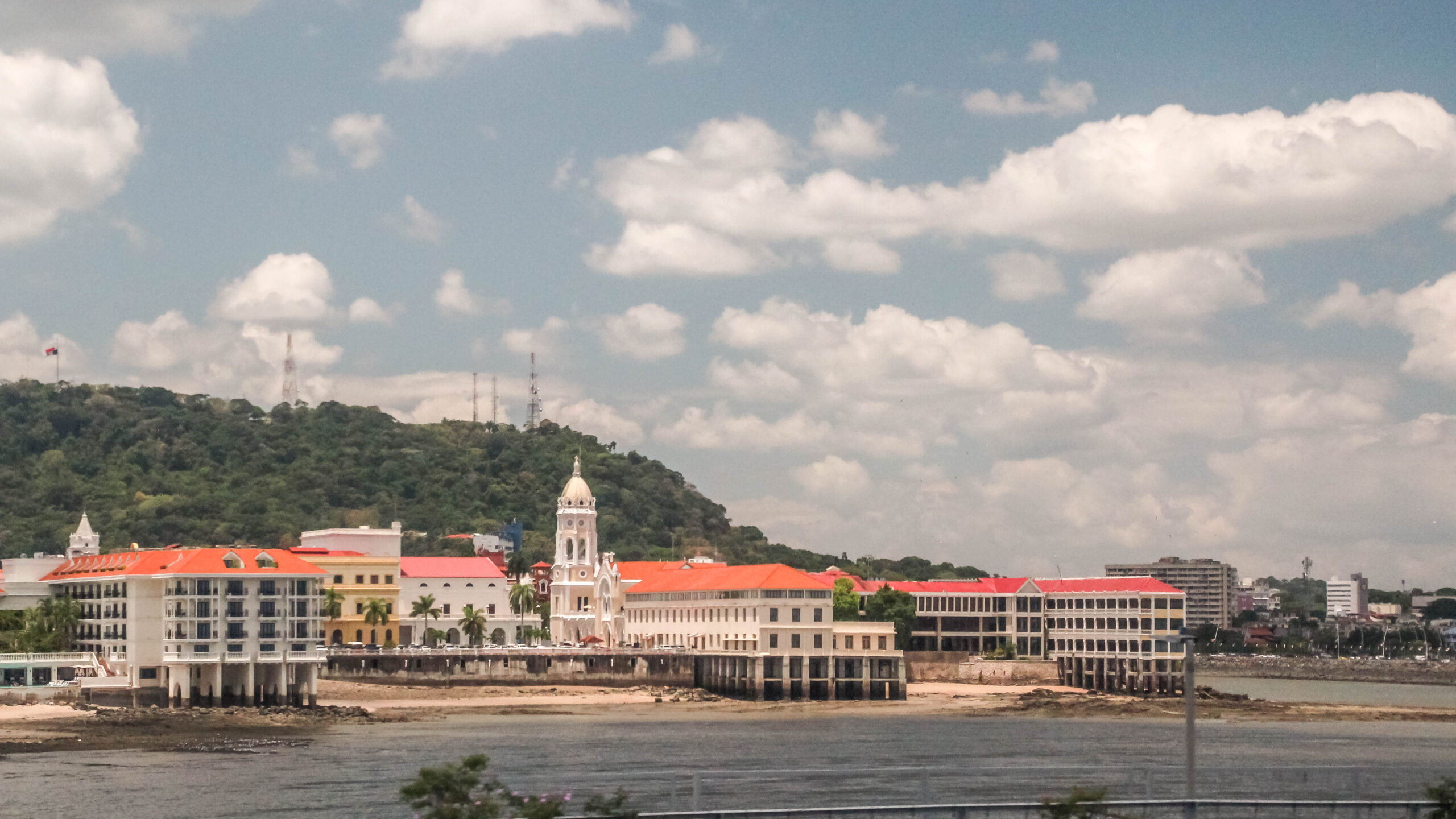 An image of the historical district of Casco Viejo in Panama City. The buildings are white with orange rooves on the beach.