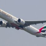 A Boeing 777 aeroplane from Emirates airline taking off and climbing into the sky.