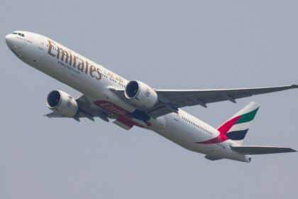 A Boeing 777 aeroplane from Emirates airline taking off and climbing into the sky.