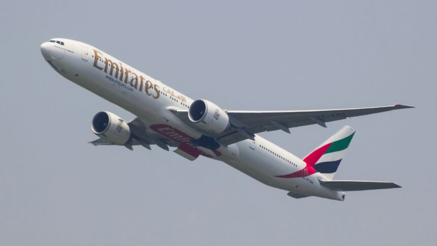 A Boeing 777 aeroplane from Emirates airline taking off and climbing into the sky.
