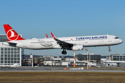 A Turkish Airlines white and red plane taking off, emphasizing its aerodynamic shape and bold color contrast.