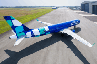 JetBlue Airbus A321 aircraft in bright blue livery parked on a tarmac at an airport.