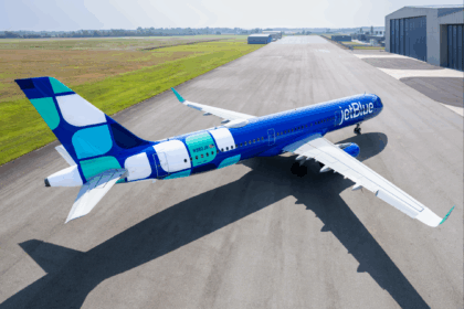 JetBlue Airbus A321 aircraft in bright blue livery parked on a tarmac at an airport.