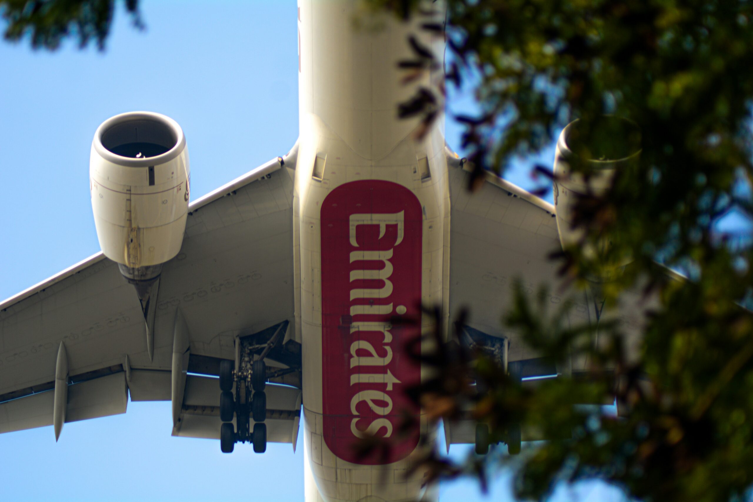 The underside view of a large aeroplane showcasing its wings, landing gear, and fuselage structure.