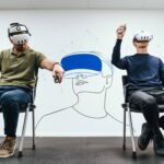 Two men seated on chairs, wearing virtual reality headsets, engaged in an immersive digital experience of pilot training provided by Air Bus and Lufthansa Aviation Training.