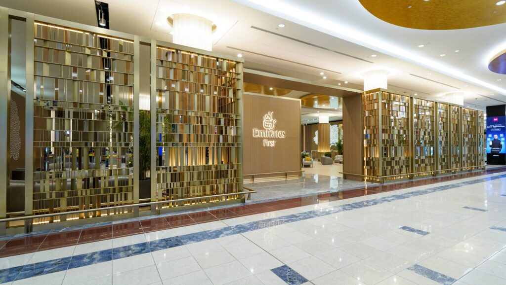 Golden entryway saying 'Emirates First' signifying entrance for Emirates First Class lounges, located at Terminal 3 at Dubai International Airport.
