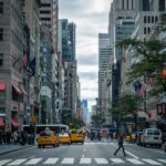 A busy street in New York with people crossing the road and traffic in the background