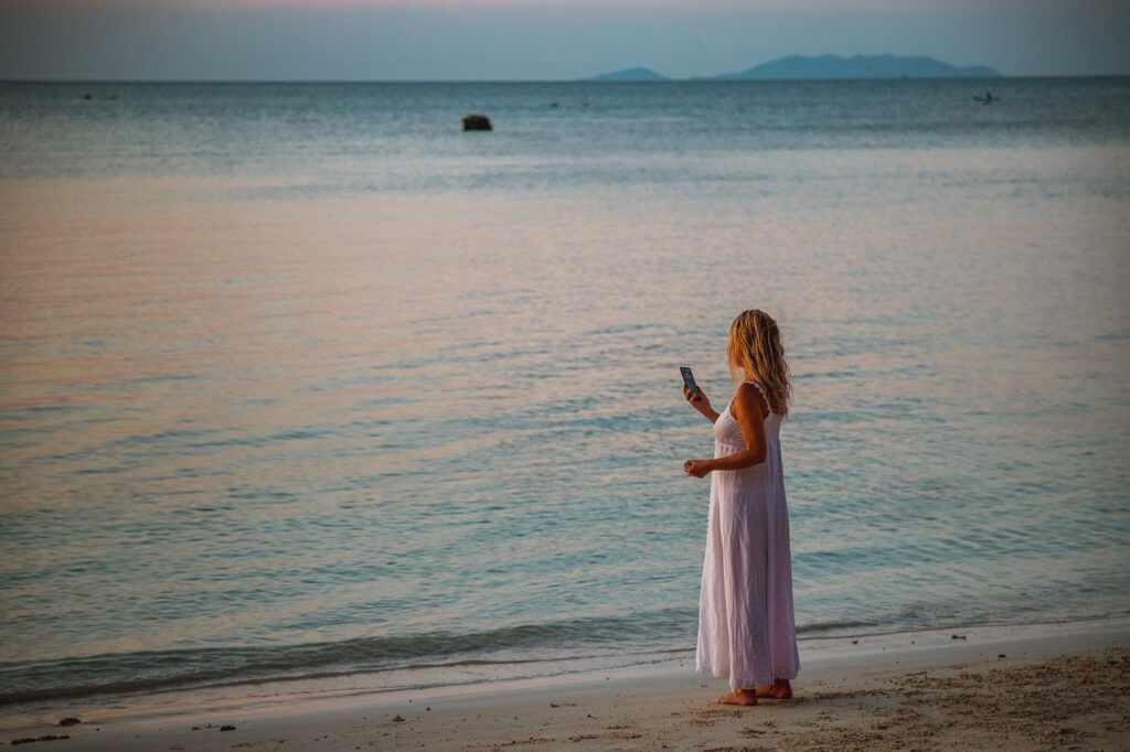 A woman taking a picture of the sea