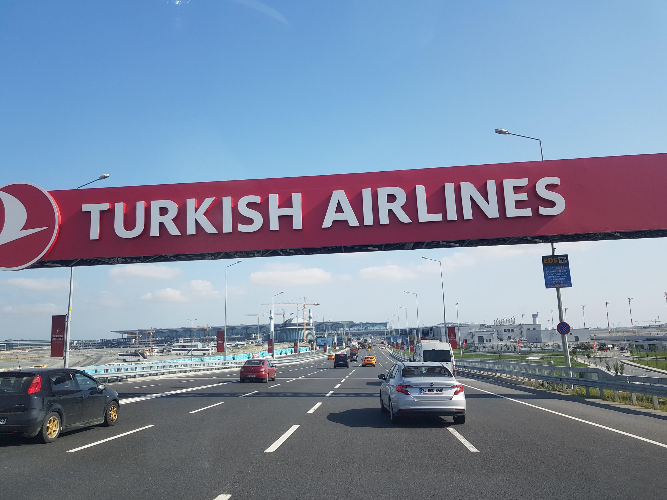 A motorway leading to Istanbul Ataturk Airport with a large road sign above reading "Turkish Airlines".