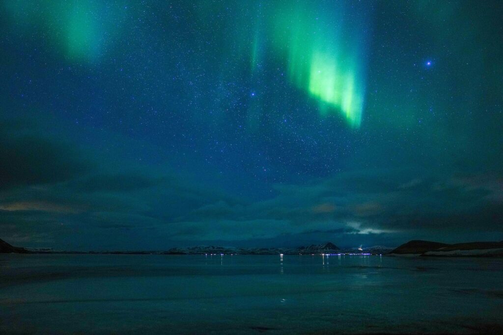 The Northern Lights, flashes of green and blue waves in the night sky as visible over Iceland.