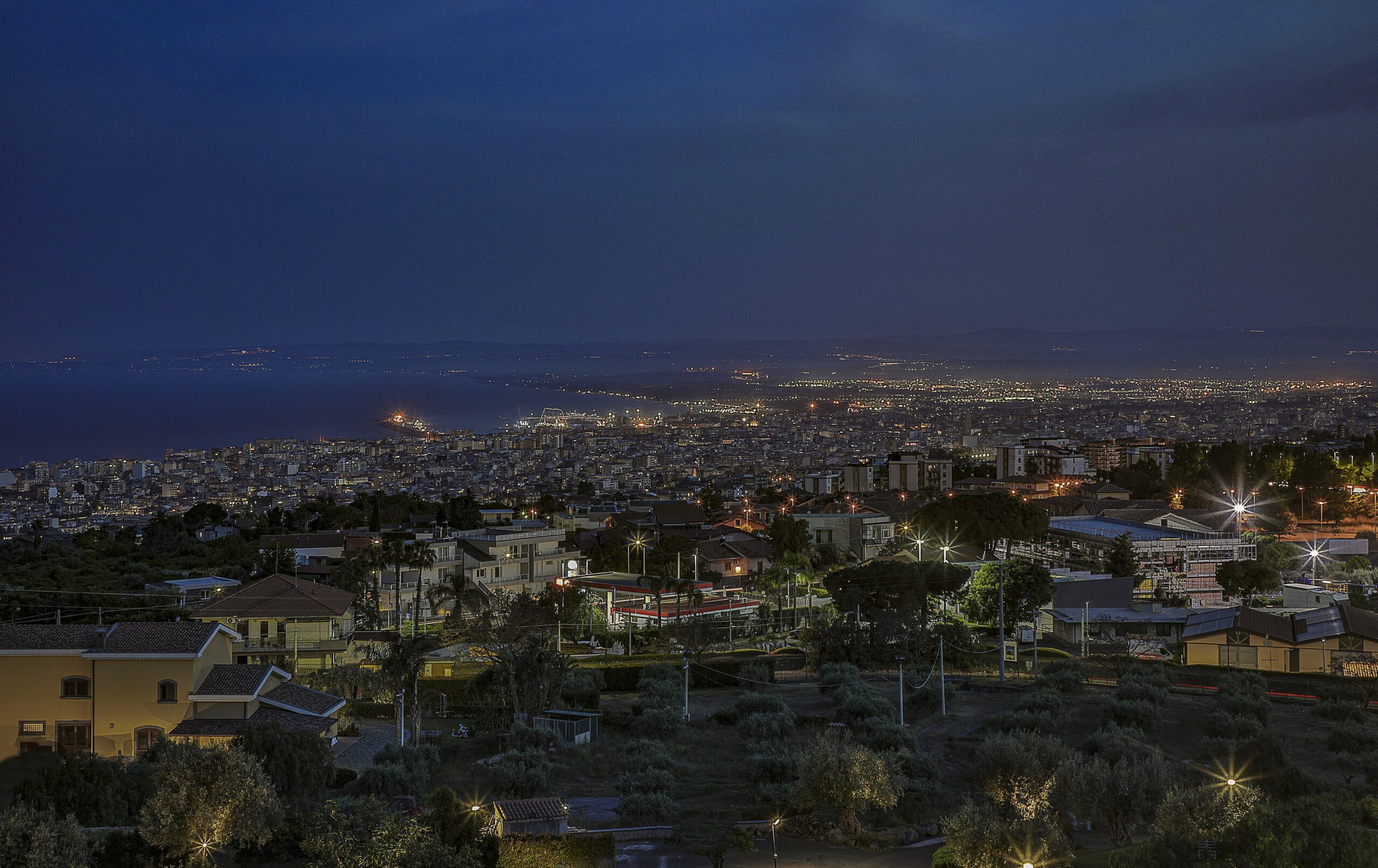 A view of Catania, Italy at night, with its streets lit up by city lights.