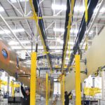 Suspended all-composite A350 XWB lower and upper wing covers in Airbus wing factory, Broughton, Wales, UK during Airbus UK workers strike 2025, highlighting Airbus industrial action across UK sites amid Airbus pay dispute, part of ongoing Airbus strike affecting UK aviation.