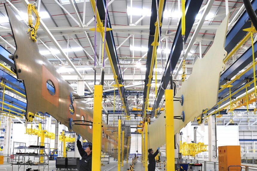 Suspended all-composite A350 XWB lower and upper wing covers in Airbus wing factory, Broughton, Wales, UK during Airbus UK workers strike 2025, highlighting Airbus industrial action across UK sites amid Airbus pay dispute, part of ongoing Airbus strike affecting UK aviation.