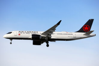 An Air Canada A220 in the air.