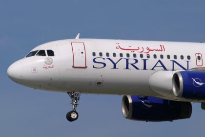 The nose of a Syrian Air A320 aircraft with landing gear out.
