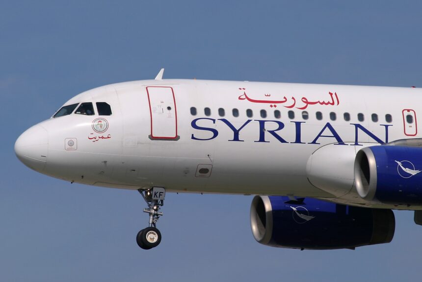 The nose of a Syrian Air A320 aircraft with landing gear out.