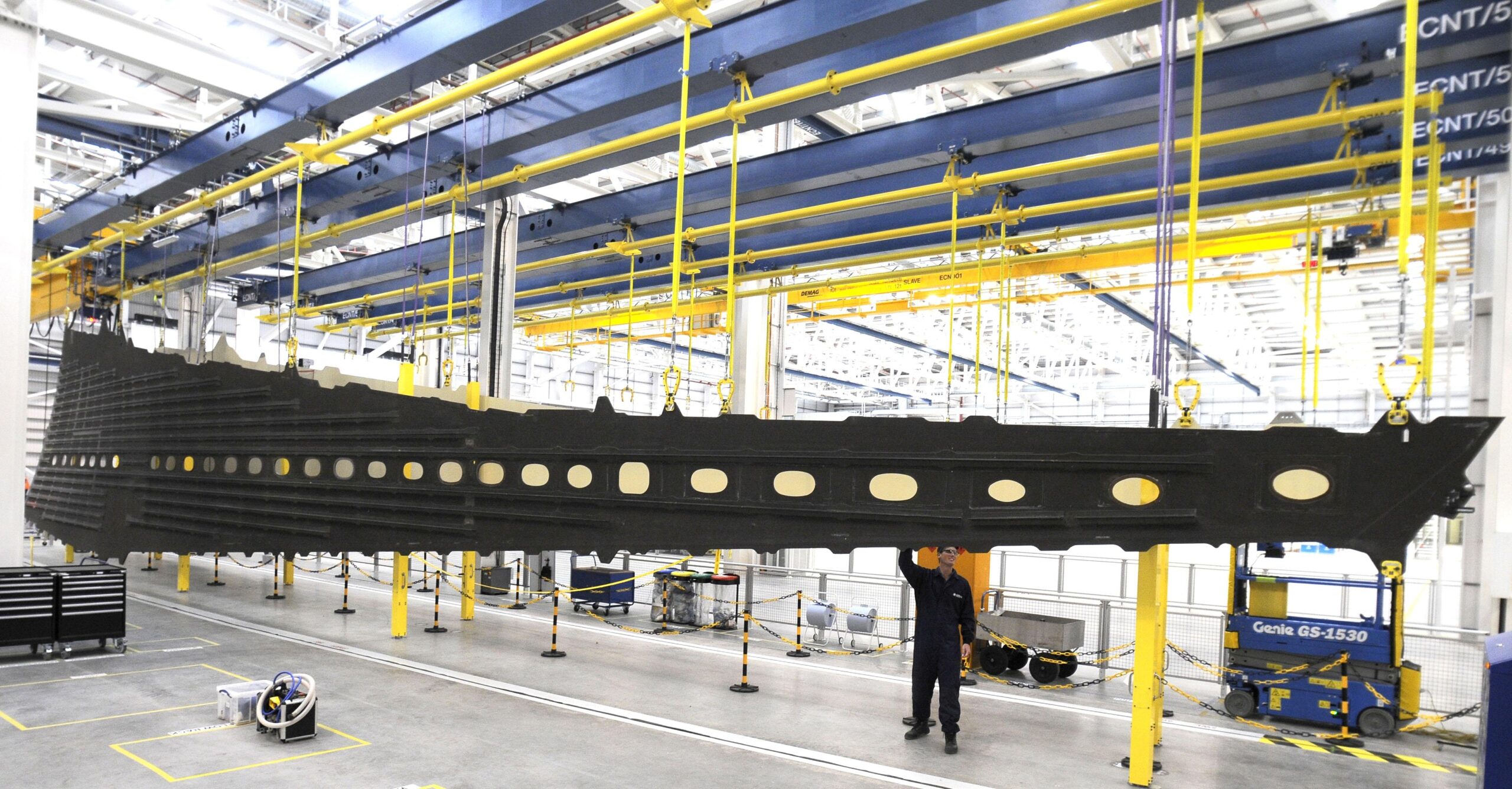 Worker at Airbus Broughton factory with suspended A350 wing cover, illustrating story on Airbus UK strike 2025.