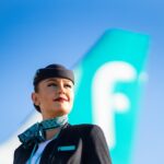 Woman flight attendant stood in front of an airplane