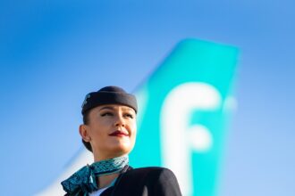 Woman flight attendant stood in front of an airplane